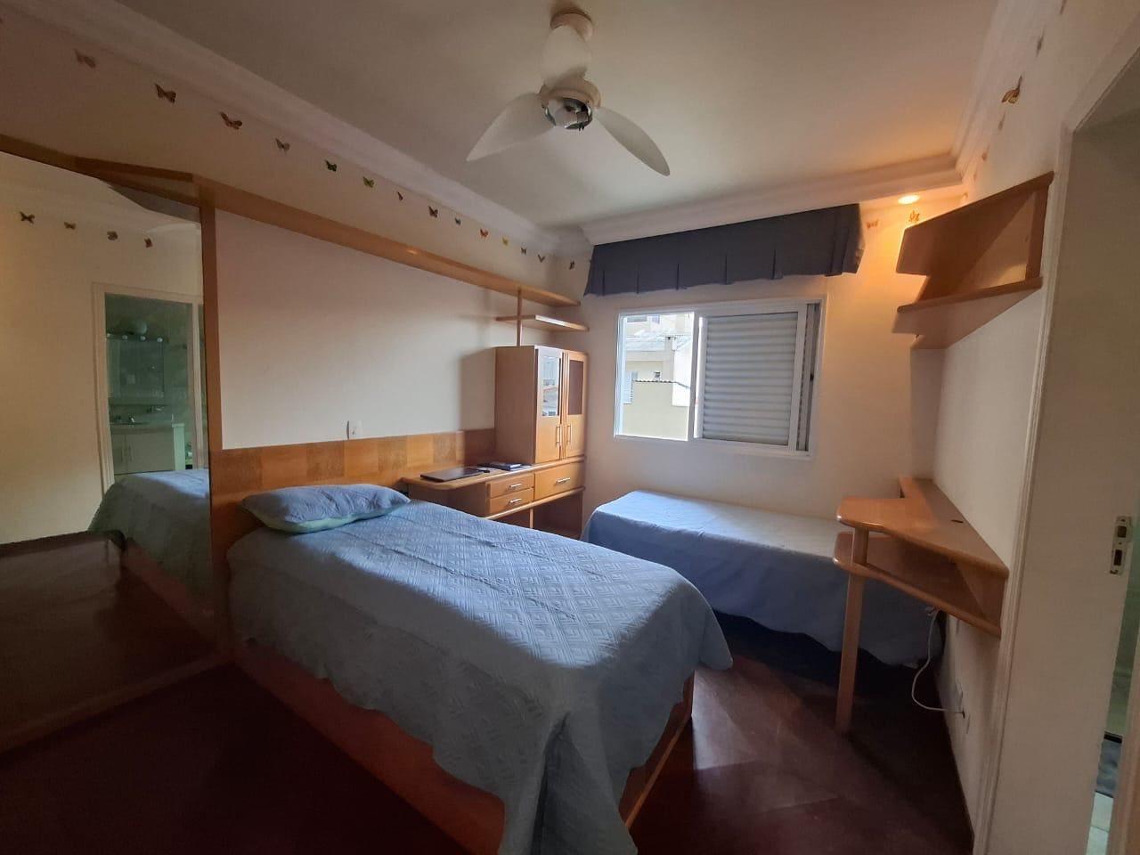 Quarto com duas camas, janela e ventilador de teto