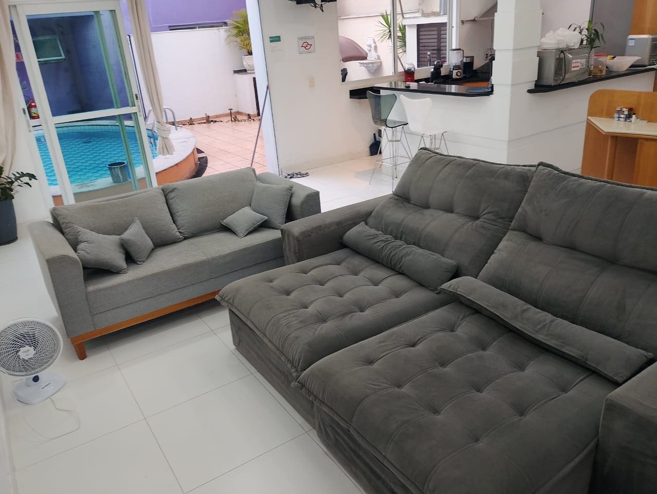 Sofás em sala compartilhada próxima a uma bancada