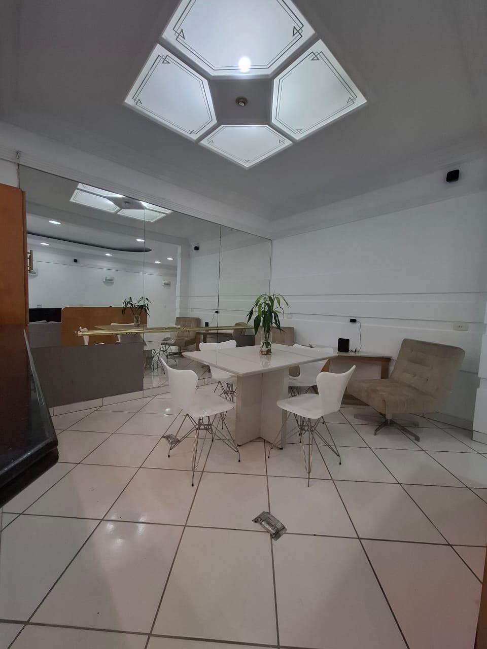 Ambiente interno com mesa de refeições e acesso à cozinha